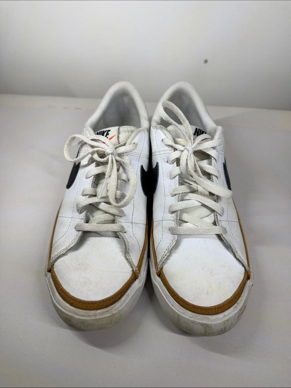 Nike White Low-Top Sneakers with Black Swoosh and Brown Trim